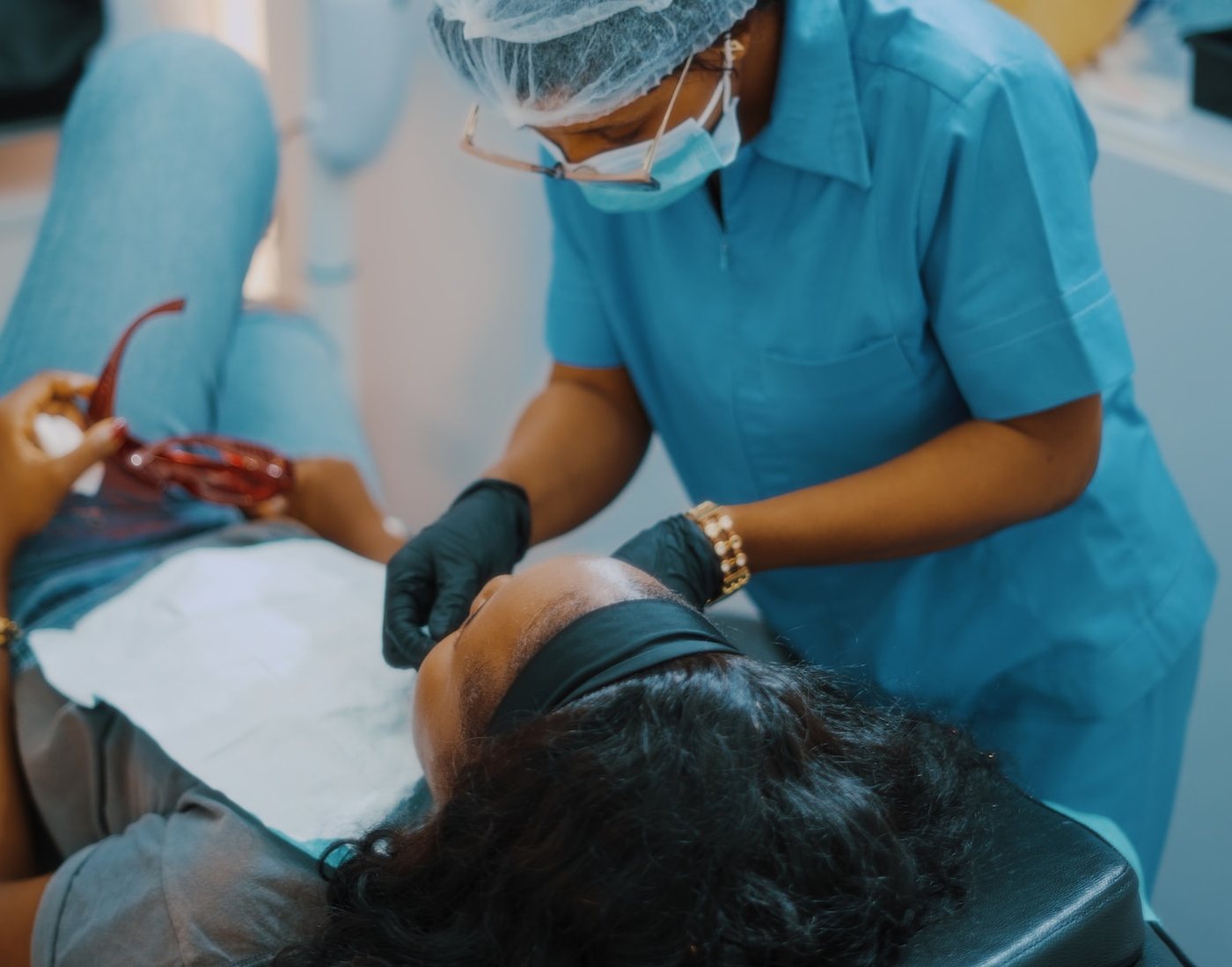 A dental hygienist treating a patient in the chair